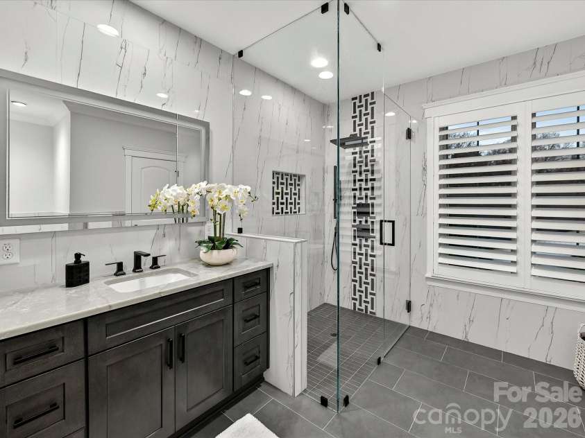 18014 Whispering Oaks Drive, Cornelius, NC 28031.  MLS# CAR4356897, YatesRealty ID 16097. Stylish ensuite bath features a designer vanity, oversized frameless glass walk-in shower with custom tilework, and upscale modern finishes.