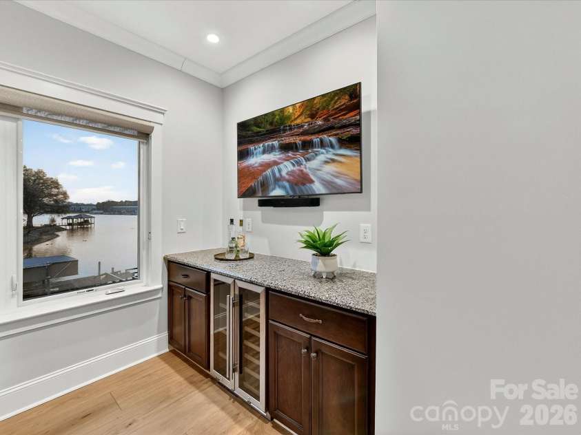 18014 Whispering Oaks Drive, Cornelius, NC 28031.  MLS# CAR4356897, YatesRealty ID 16097. The second-floor wet bar features granite countertops, built-in beverage refrigerators, and a convenient serving area for effortless entertaining.