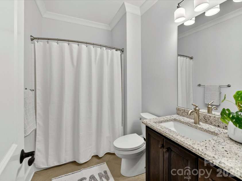 18014 Whispering Oaks Drive, Cornelius, NC 28031.  MLS# CAR4356897, YatesRealty ID 16097. Well-appointed full bath features a granite-topped vanity, tile flooring, and a tub/shower combination, offering both style and everyday convenience.