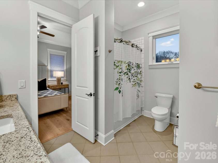 18014 Whispering Oaks Drive, Cornelius, NC 28031.  MLS# CAR4356897, YatesRealty ID 16097. Well-appointed guest ensuite bath features a granite-topped vanity, generous storage, and stylish finishes for comfort and convenience.
