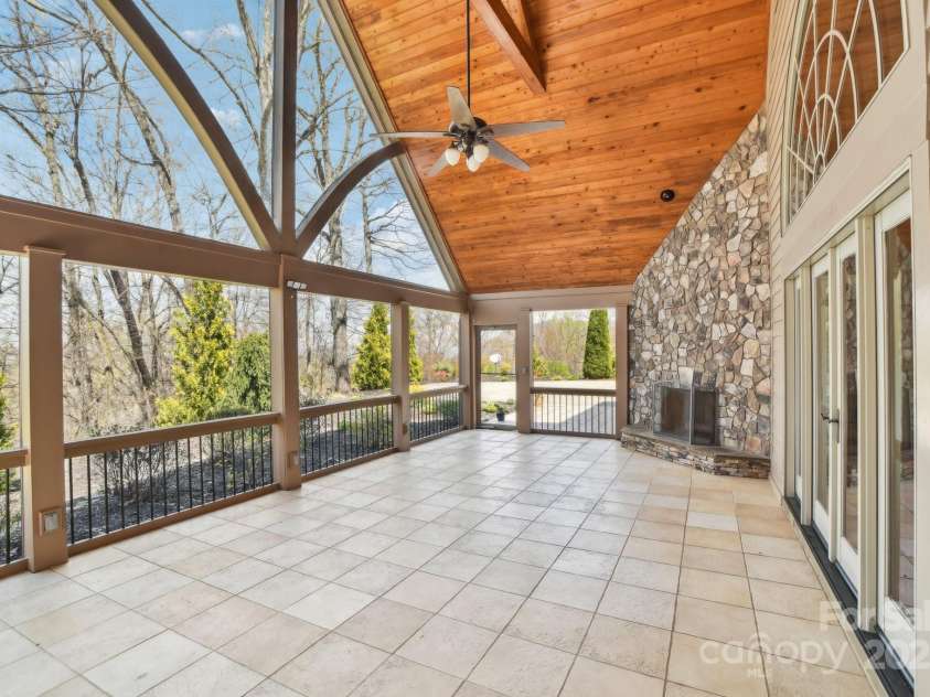 206 View Ridge Parkway, Leicester, NC 28748.  MLS# CAR4228261, YatesRealty ID 16135. An incredible screened-in porch featuring vaulted ceilings and a stunning stone fireplace