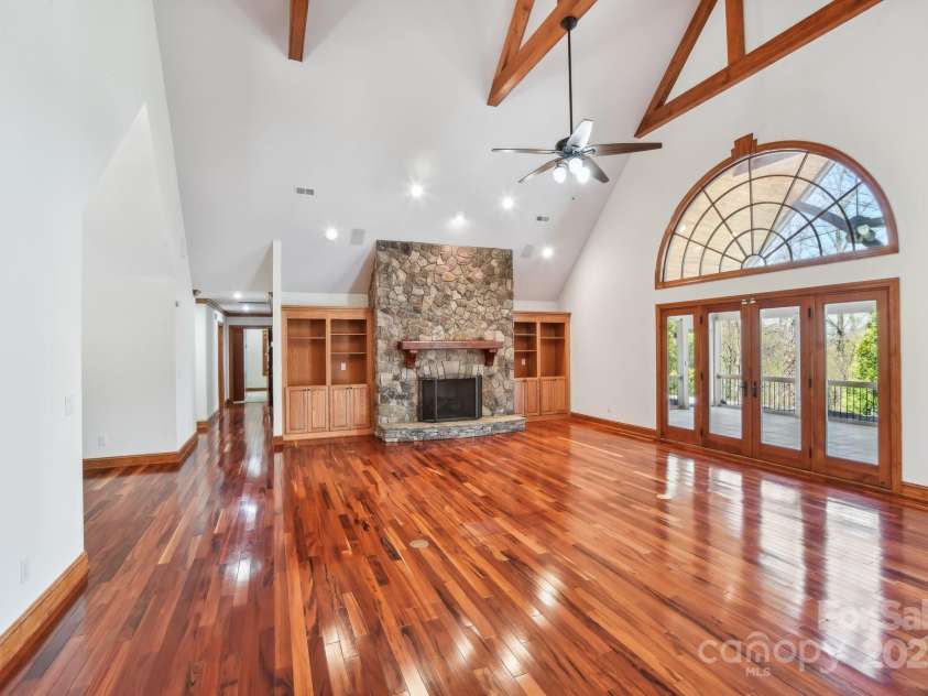 206 View Ridge Parkway, Leicester, NC 28748.  MLS# CAR4228261, YatesRealty ID 16135. The great room impresses with vaulted ceilings, gleaming wood floors, and a striking stone fireplace—bringing warmth and grandeur to the heart of the home