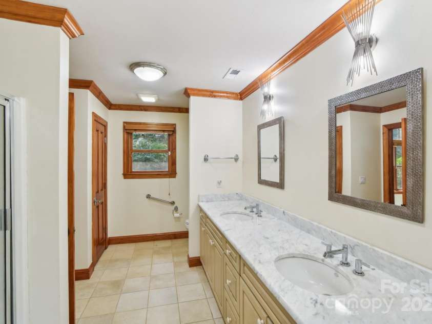 206 View Ridge Parkway, Leicester, NC 28748.  MLS# CAR4228261, YatesRealty ID 16135. The second bathroom boasts dual vanities, providing added convenience and space for busy mornings