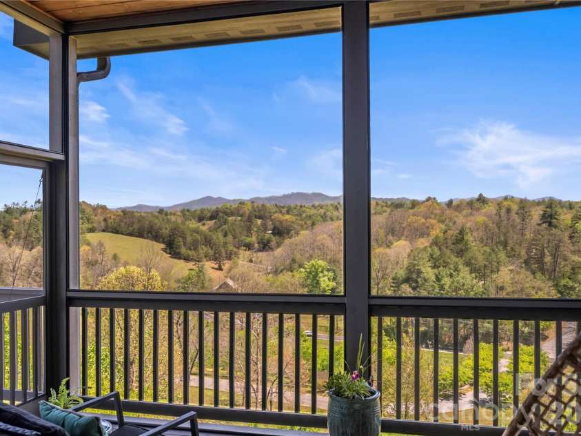 28 Gracie Lane, Weaverville, NC 28787.  MLS# CAR4361054, YatesRealty ID 16155. Elevated views provide a quiet, scenic backdrop from the screened-in porch.