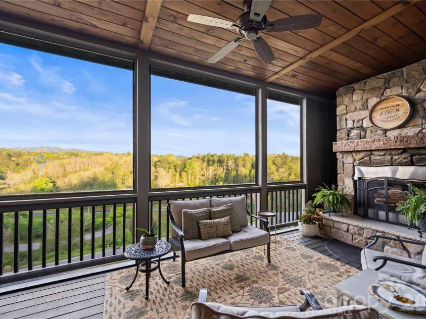28 Gracie Lane, Weaverville, NC 28787.  MLS# CAR4361054, YatesRealty ID 16155. Screened porch with wood-burning fireplace offers a comfortable space to enjoy the views year-round.