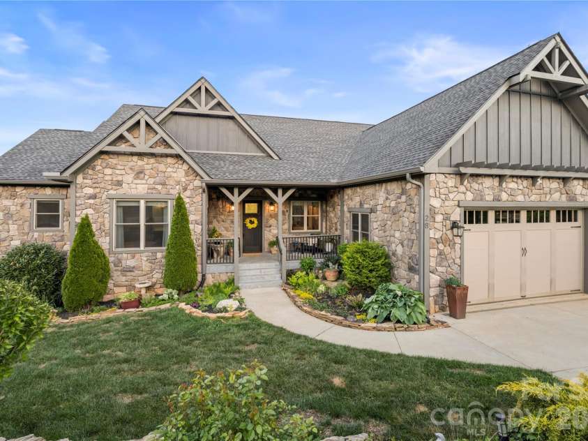 28 Gracie Lane, Weaverville, NC 28787.  MLS# CAR4361054, YatesRealty ID 16155. Stone and siding exterior with a welcoming covered entry and lush landscaping.