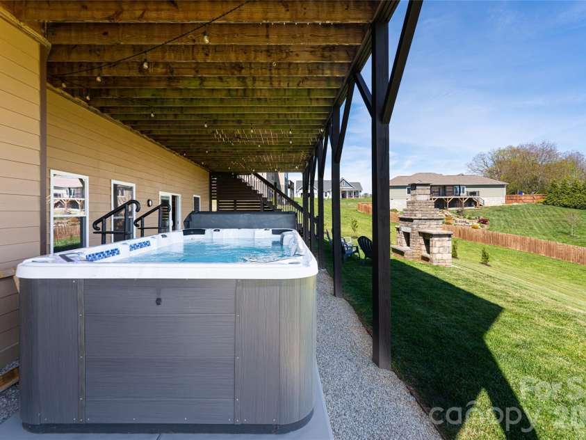 12 Horizon View Lane, Alexander, NC 28701.  MLS# CAR4373999, YatesRealty ID 16165. Lower Level terrace with fireplace and swim spa