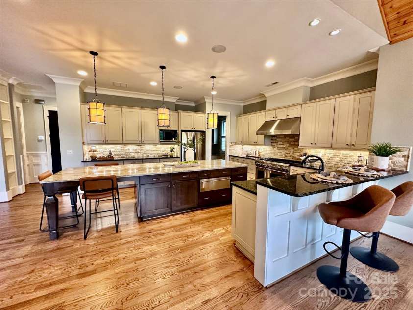 18420 Rosapenny Road, Charlotte, NC 28278.  MLS# CAR4240682, YatesRealty ID 16172. Chef's kitchen with warming drawer and luury appliances connecting dining, upper deck and living room