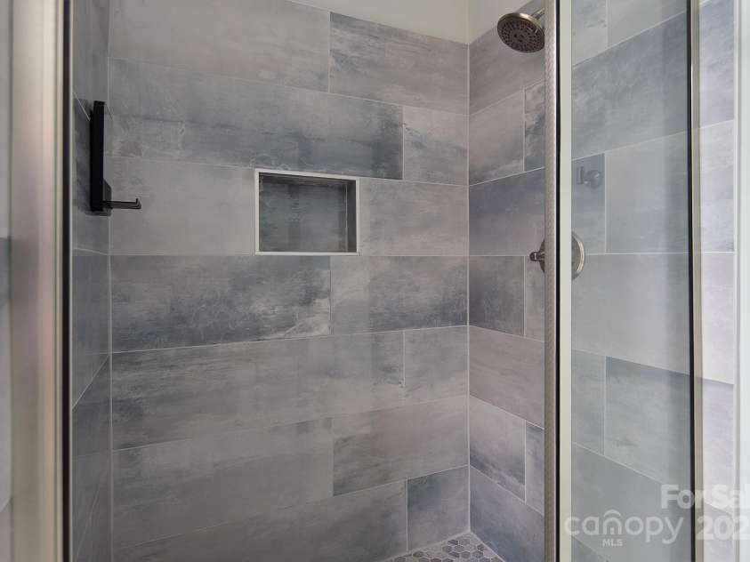 7007 Chapparall Lane, Charlotte, NC 28215.  MLS# CAR4223263, YatesRealty ID 16192. Fully Renovated Primary Shower with niche