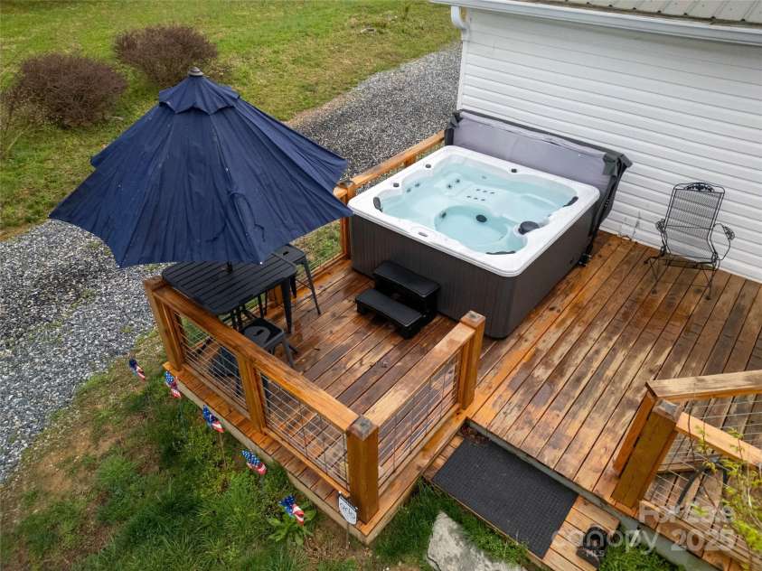 626 Fairview Loop, Hot Springs, NC 28743.  MLS# CAR4302454, YatesRealty ID 1621. Rear Deck with the hot tub and high-top table on its left side.