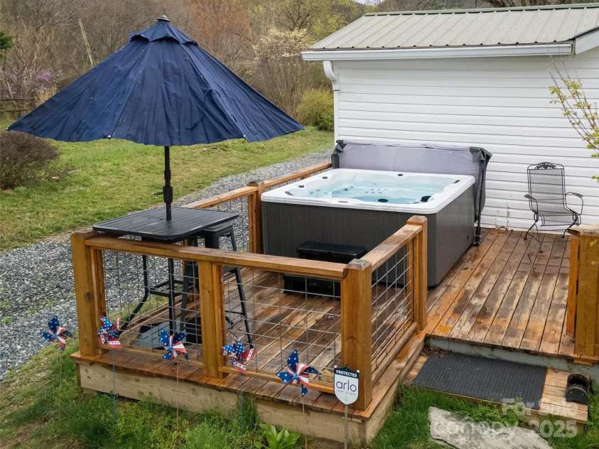 626 Fairview Loop, Hot Springs, NC 28743.  MLS# CAR4302454, YatesRealty ID 1621. Rear Deck with the hot tub and high-top table on its left side.