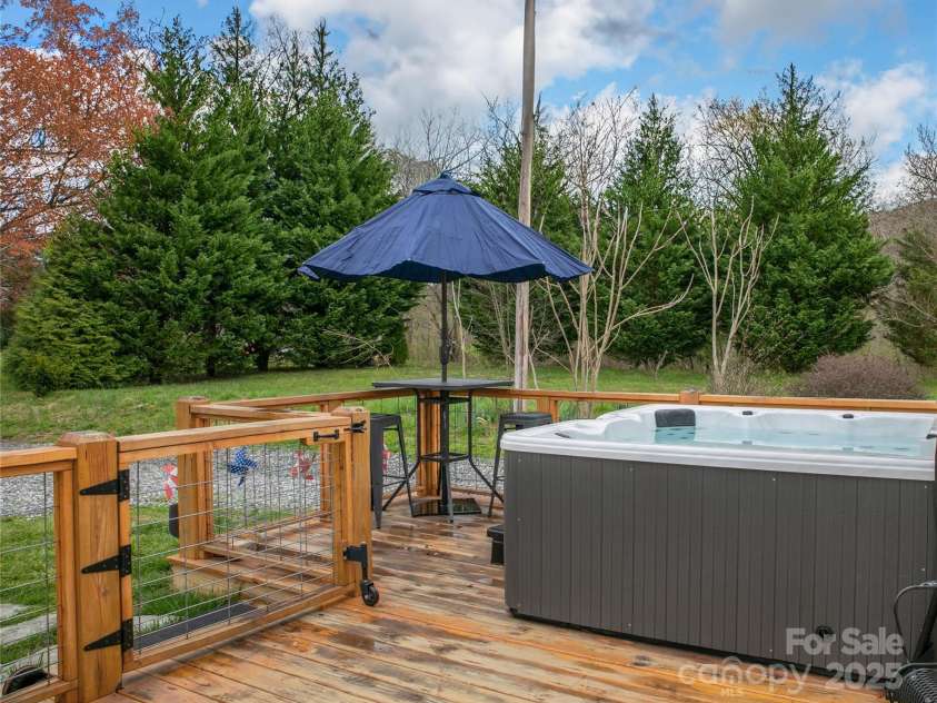 626 Fairview Loop, Hot Springs, NC 28743.  MLS# CAR4302454, YatesRealty ID 1621. Rear Deck with the hot tub and high-top table on its left side.