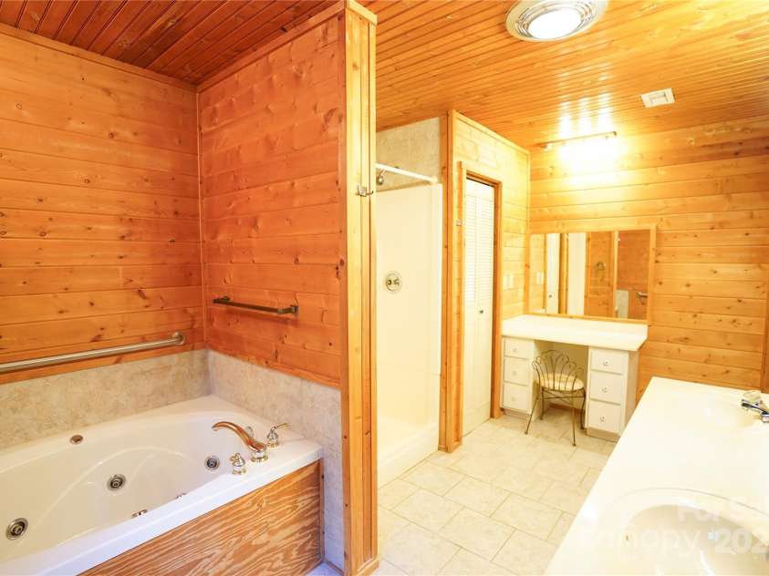 262 Rooster Cove, Brevard, NC 28712.  MLS# CAR4332799, YatesRealty ID 1626. Large bathroom with shower, whirlpool tub, double vanity and large linen closet off of large main level bedroom