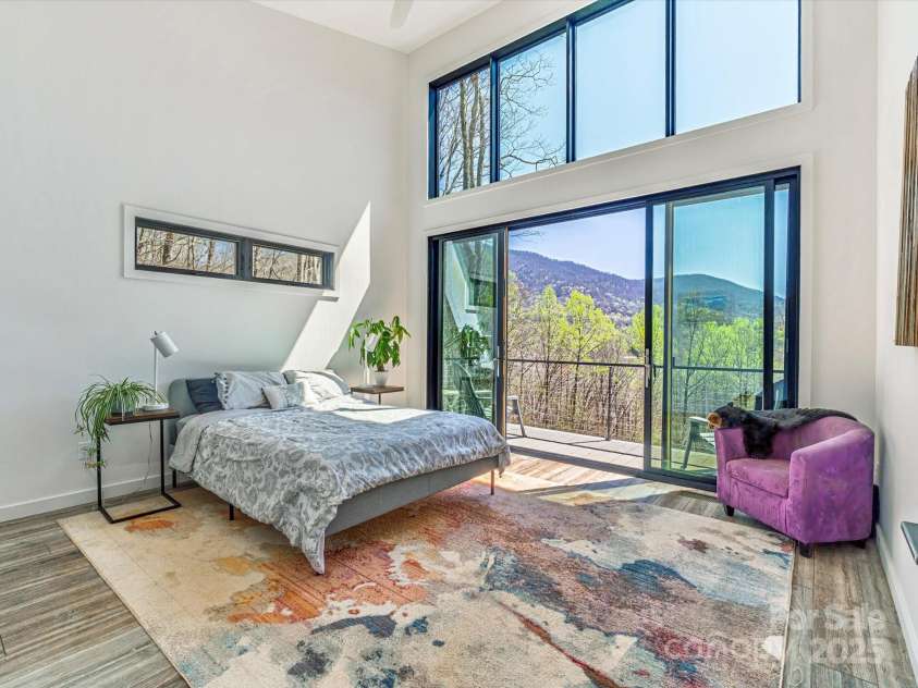 75 Ladyslipper Lane, Waynesville, NC 28786.  MLS# CAR4241976, YatesRealty ID 16337. Primary bedroom with floor to ceiling windows