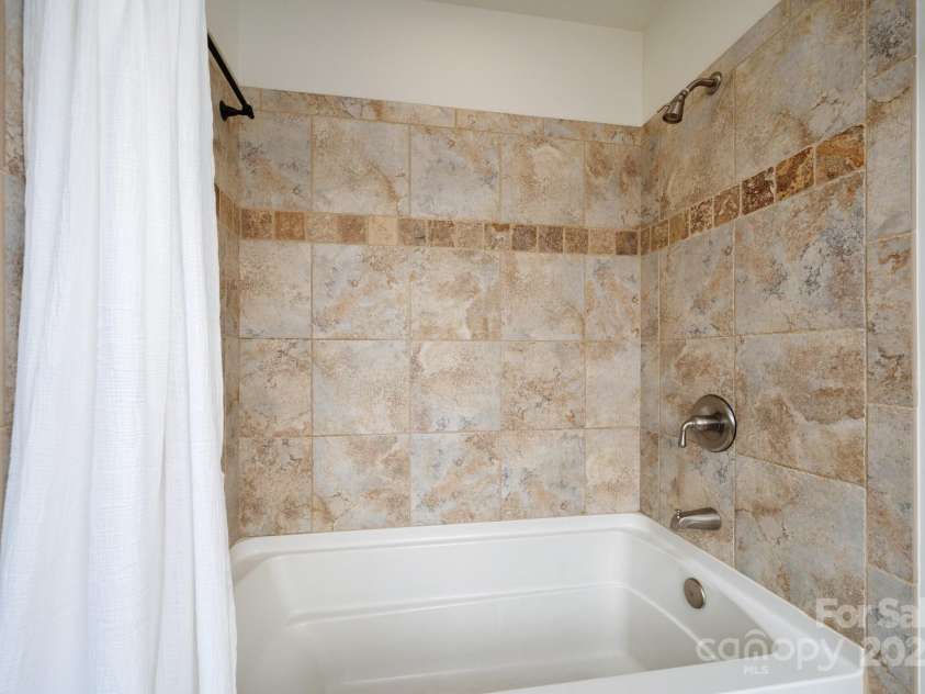 20 Grandview Drive, Asheville, NC 28806.  MLS# CAR4254983, YatesRealty ID 16343. Tiled primary bathroom shower and tub combo