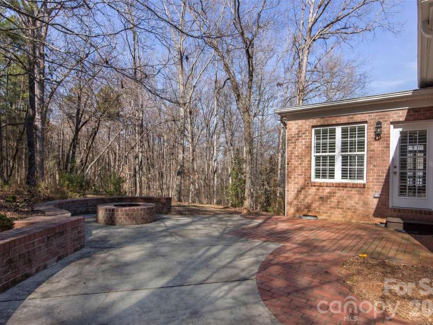 4709 Trey View Court, Mint Hill, NC 28227.  MLS# CAR4173427, YatesRealty ID 16368. Enjoy friends and family gatherings around custom brick firepit - concrete/brick patio - door leads to sunroom/dining room and walkway extending down side of house to 29 ft deck!