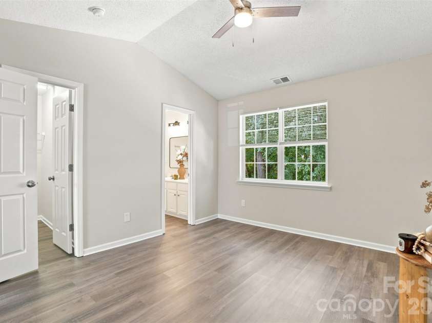 6766 Cypress Tree Lane, Charlotte, NC 28215.  MLS# CAR4415142, YatesRealty ID 16391. Spacious primary bedroom with a vaulted ceiling and updated ceiling fan