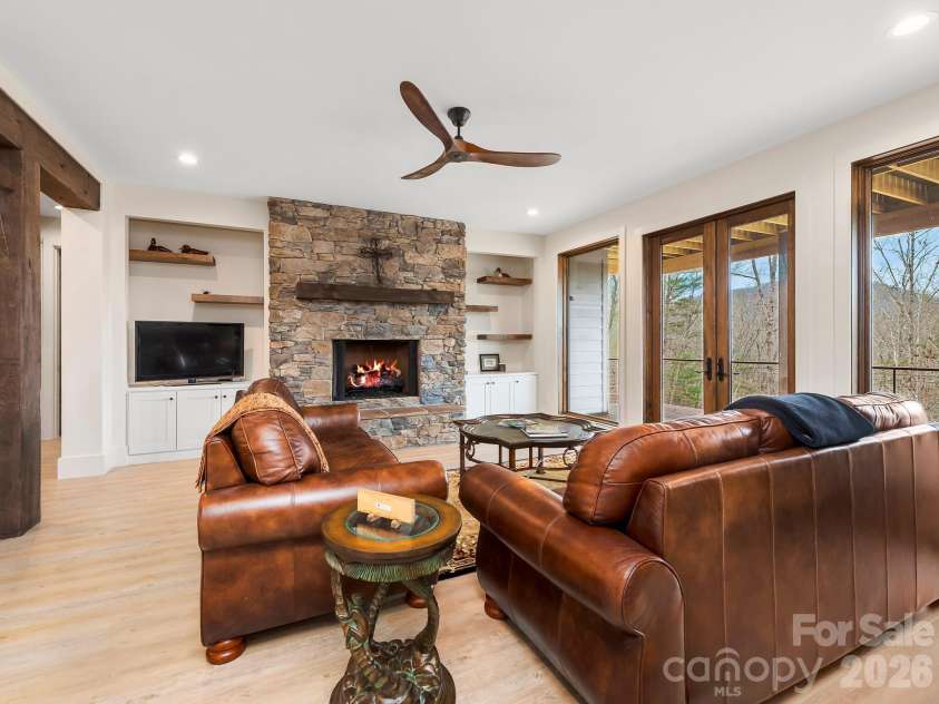 567 Wild River Run, Marshall, NC 28753.  MLS# CAR4353270, YatesRealty ID 16403. Lower level living area with a stacked stone fireplace.