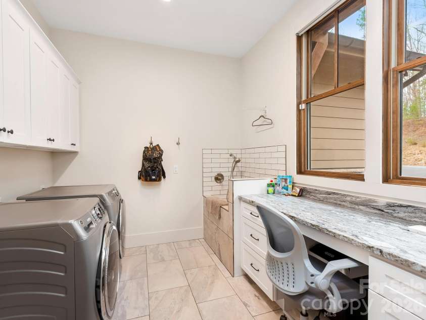 567 Wild River Run, Marshall, NC 28753.  MLS# CAR4353270, YatesRealty ID 16403. Main level laundry room with desk and pet bathing station.