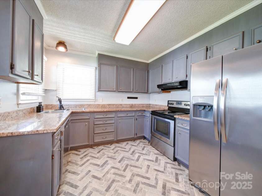 3530 Farm Lake Drive, Concord, NC 28027.  MLS# CAR4246396, YatesRealty ID 16470. The Kitchen features Gray Cabinets and Stainless Appliances. Notice the Custom Gray Tone Chevron Style Vinyl Tile Floors.