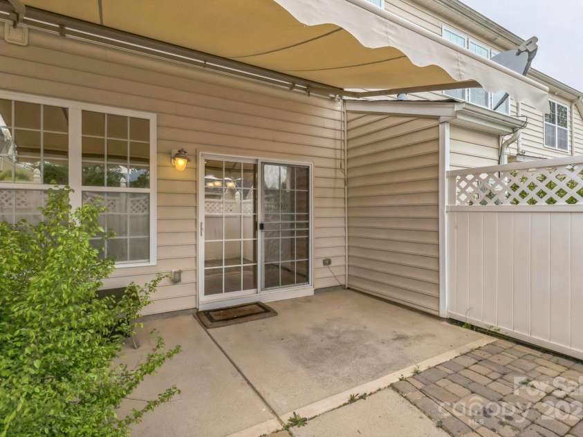 8009 Whitehawk Hill Road, Waxhaw, NC 28173.  MLS# CAR4232872, YatesRealty ID 16475. Private fenced patio with a powered awning, creating the perfect outdoor retreat.