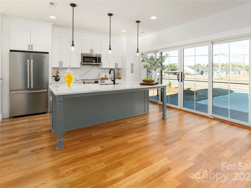 106 Isle Of Pines Road, Mooresville, NC 28117.  MLS# CAR4307196, YatesRealty ID 165. Stunning kitchen with expansive wall of sliders to deck.  Site finished hardwoods.  Interior of lot 1 home.
