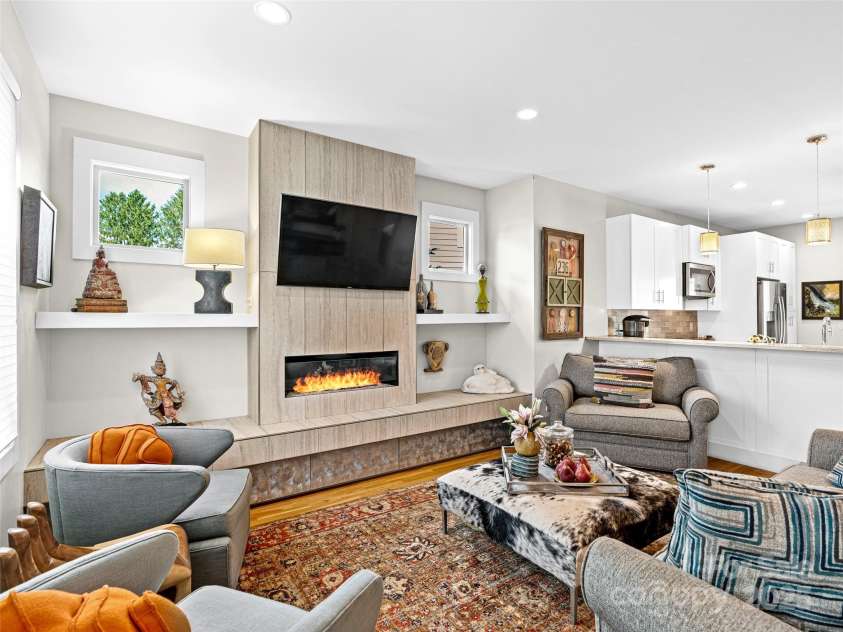 40 Overlook Road, Asheville, NC 28803.  MLS# CAR4300560, YatesRealty ID 16528. Light-filled living room with a cozy fireplace — perfect for relaxing or entertaining.