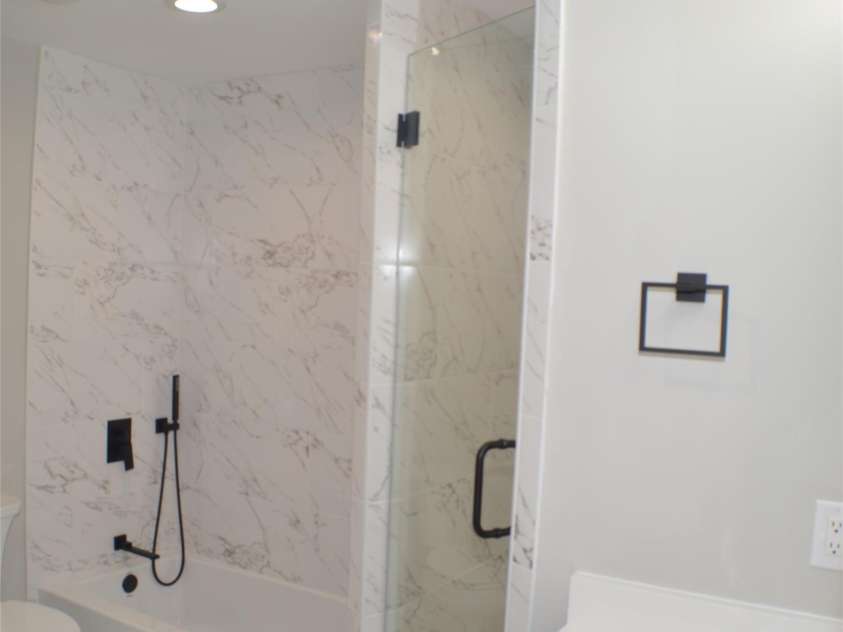 2000 Tyvola Road, Charlotte, NC 28210.  MLS# CAR4260481, YatesRealty ID 16600. A private en-suite bath adorned with high-end finishes, including quartz countertops, custom tile work, tiled tub surrounds, and frameless glass showers—offering a spa-like retreat right at home.