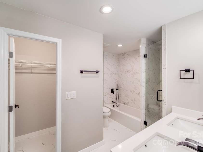 2000 Tyvola Road, Charlotte, NC 28210.  MLS# CAR4260481, YatesRealty ID 16600. Unwind in your private en-suite bath, thoughtfully designed with warm, high-end finishes—featuring quartz countertops, custom tile details, tiled tub surrounds, and a frameless glass shower. Just steps away, a spacious wa