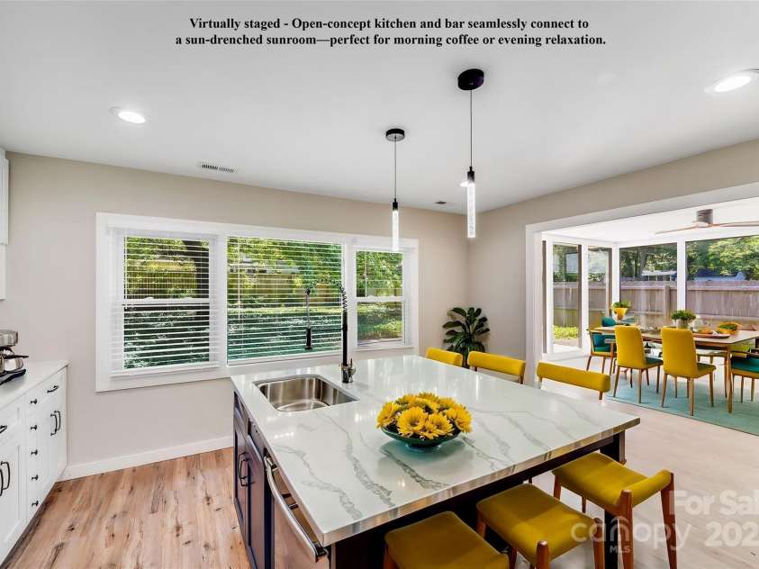 2000 Tyvola Road, Charlotte, NC 28210.  MLS# CAR4260481, YatesRealty ID 16600. Virtually staged - Open-concept kitchen and bar seamlessly connect to a sun-drenched sunroom—perfect for morning coffee or evening relaxation.