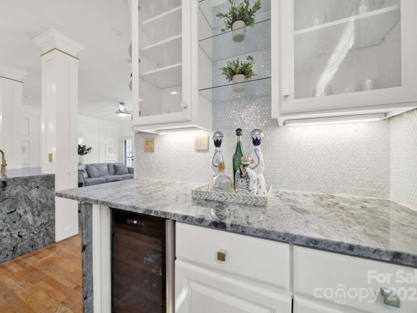 1569 Benjamen Latrobe Circle, Fort Mill, SC 29708.  MLS# CAR4235857, YatesRealty ID 16622. Chef's Kitchen - Exotic Waterfall Granite Counter Tops, White Tile Backsplash, Farm House Sink, High End Appliances, Designer Lighting, Wood Floors, Custom Wine Bar, Walk-In Pantry