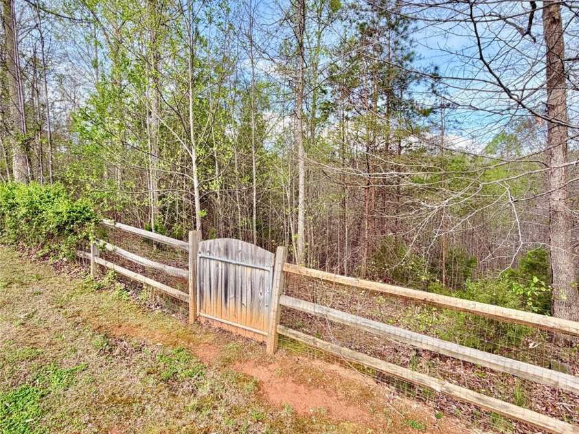1142 Clearwater Parkway, Rutherfordton, NC 28139.  MLS# CAR4366503, YatesRealty ID 16637. Back gate that leads down to small creek