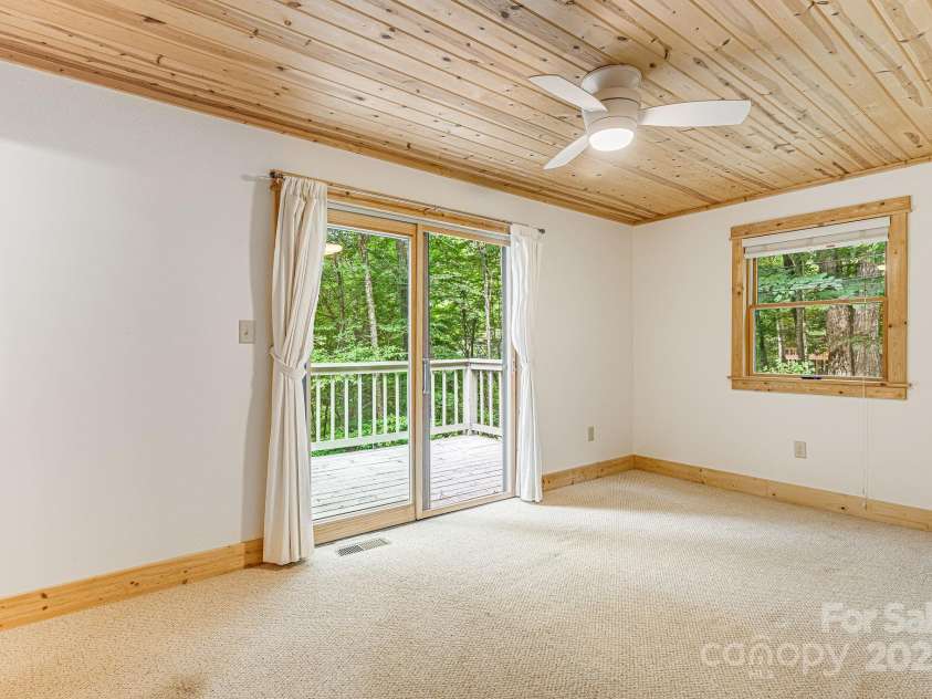 73 Oak Ridge Court, Mars Hill, NC 28754.  MLS# CAR4166537, YatesRealty ID 1667. Primary bedroom with doors leading out onto the deck.