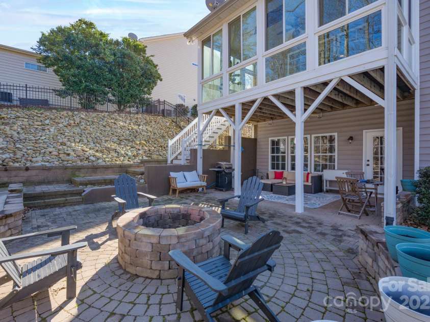 228 Black Mountain Drive, Fort Mill, SC 29708.  MLS# CAR4225909, YatesRealty ID 1671. Backyard with firepit and stairs to screened porch on main level