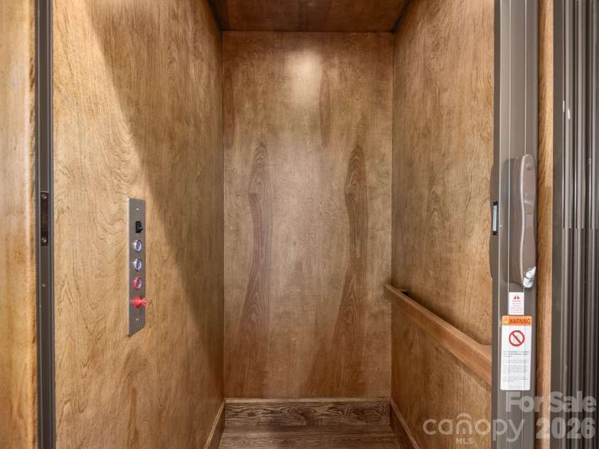 48 Verde Drive, Asheville, NC 28806.  MLS# CAR4364556, YatesRealty ID 16757. Representative photo from 50 Verde Drive showing the builder’s quality of construction and finish level, including a private residential elevator with warm wood interior finish and convenient access between levels.