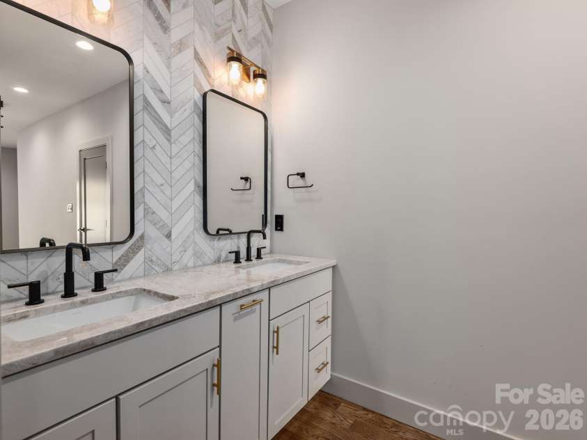 48 Verde Drive, Asheville, NC 28806.  MLS# CAR4364556, YatesRealty ID 16757. Representative photo from 50 Verde Drive showing the builder’s quality of construction and finish level, including a primary ensuite with Wolf cabinetry, granite countertops, dual sinks, designer mirrors, and a striking til