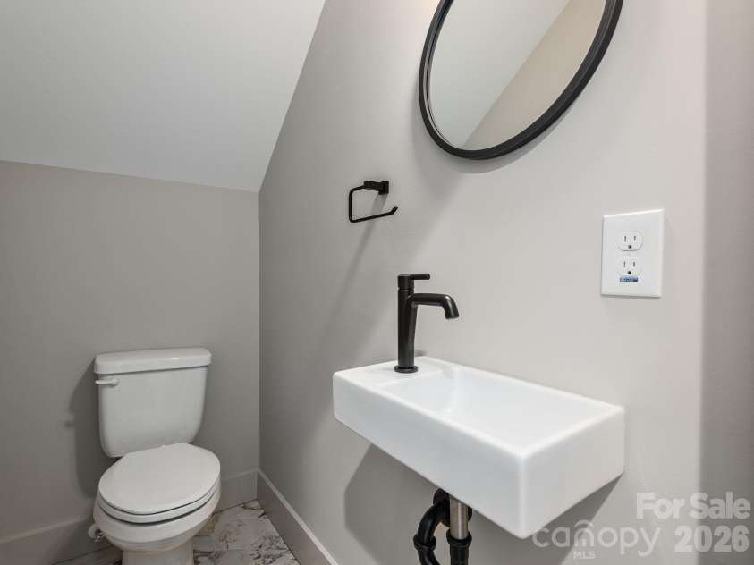 48 Verde Drive, Asheville, NC 28806.  MLS# CAR4364556, YatesRealty ID 16757. Representative photo from 50 Verde Drive showing the builder’s quality of construction and finish level, including a lower-level half bath with pedestal sink, ceramic tile flooring, and clean modern finishes.