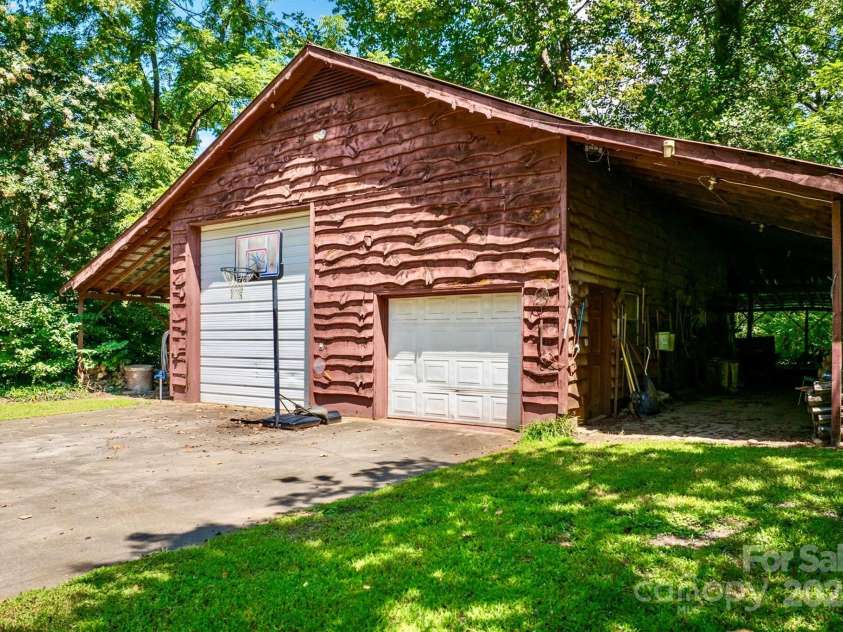 3050 Old Johns River Road, Collettsville, NC 28611.  MLS# CAR4174150, YatesRealty ID 16769. The large barn has RV storage and electric hookup, a loft, workbench, and regular size garage door.  Shed roof on both side provide protected storage for lawn and garden implements.