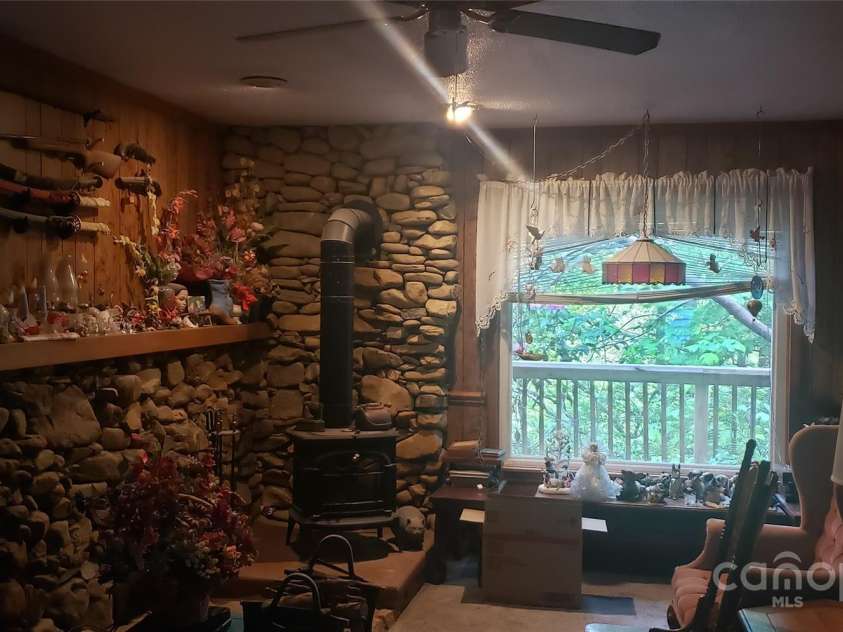 31 Samuel Lane, Candler, NC 28715.  MLS# CAR4257442, YatesRealty ID 16797. Living room with wood stove