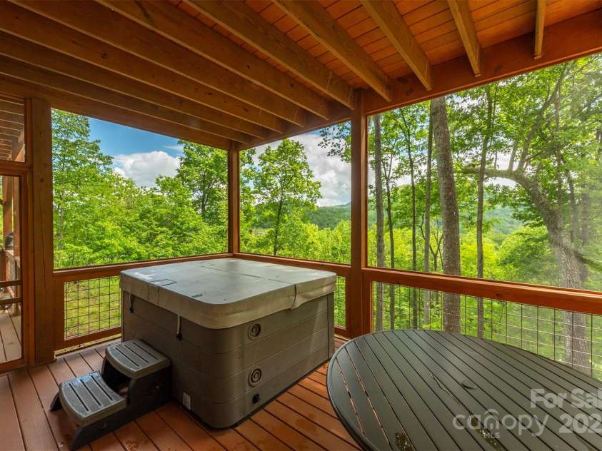 201 Ruffed Grouse Lane, Waynesville, NC 28786.  MLS# CAR4257615, YatesRealty ID 16833. Lower level screened deck with hot tub