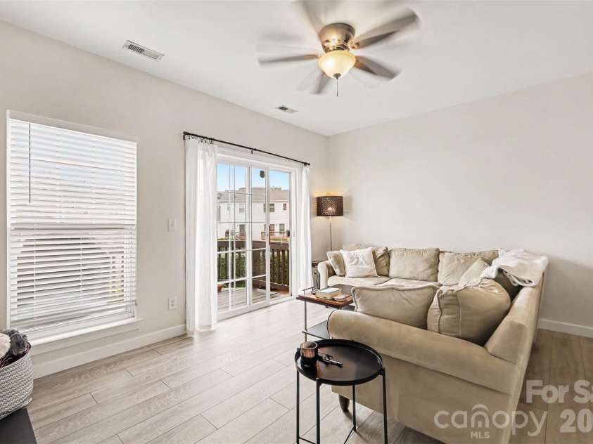 2729 Avalon Loop Road, Charlotte, NC 28269.  MLS# CAR4366095, YatesRealty ID 16859. Expansive windows and balcony doors invite natural light into the living area while seamlessly connecting the indoor and outdoor spaces.