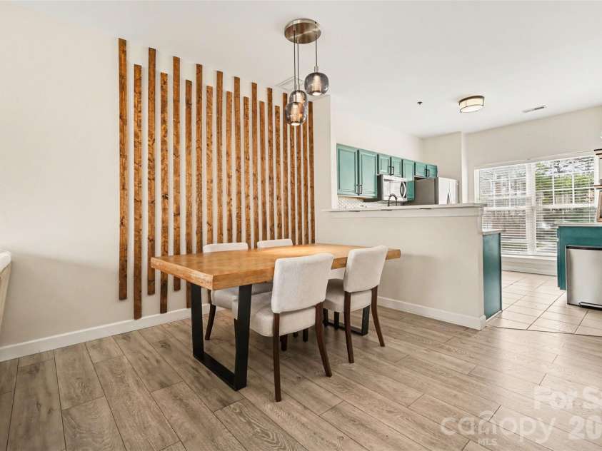 2729 Avalon Loop Road, Charlotte, NC 28269.  MLS# CAR4366095, YatesRealty ID 16859. Open-concept dining and living space showcasing a custom wood accent wall and seamless flow for everyday living and entertaining.