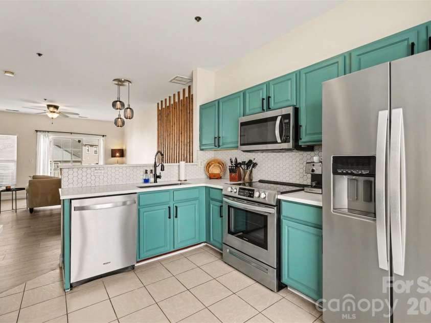 2729 Avalon Loop Road, Charlotte, NC 28269.  MLS# CAR4366095, YatesRealty ID 16859. Updated kitchen featuring stainless steel appliances, modern cabinetry, hexagon tile backsplash, and additional built-in cabinetry for stylish storage and functionality.