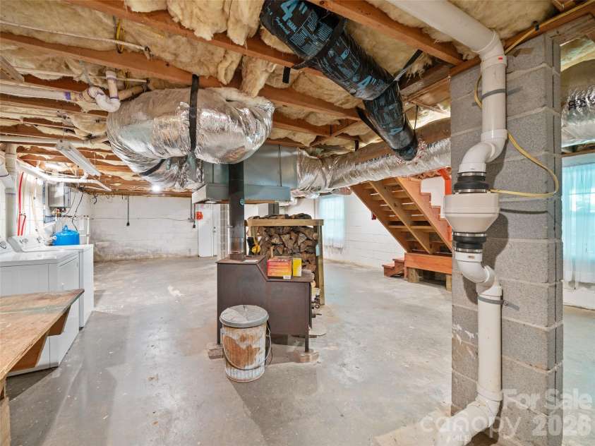 125 HEARTLAND Lane, Burnsville, NC 28714.  MLS# CAR4273356, YatesRealty ID 16873. Unfinished basement with wood stove.