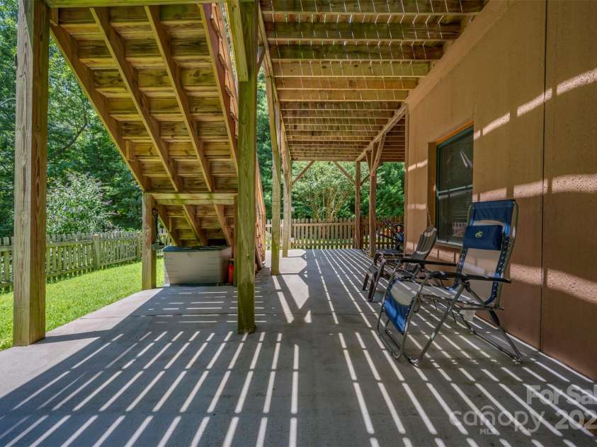 23 Jay Foster Way, Saluda, NC 28773.  MLS# CAR4278065, YatesRealty ID 1689. Full length poured concrete patio under deck.  