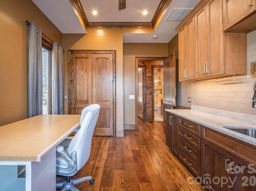 333 Kanasdatsi Drive, Brevard, NC 28712.  MLS# CAR4330137, YatesRealty ID 16902. Built-In Office / Craft RoomDedicated built-in office or craft space featuring custom cabinetry, stone countertops, tile backsplash, hardwood flooring, recessed lighting, and direct access to adjacent bath—ideal for rem