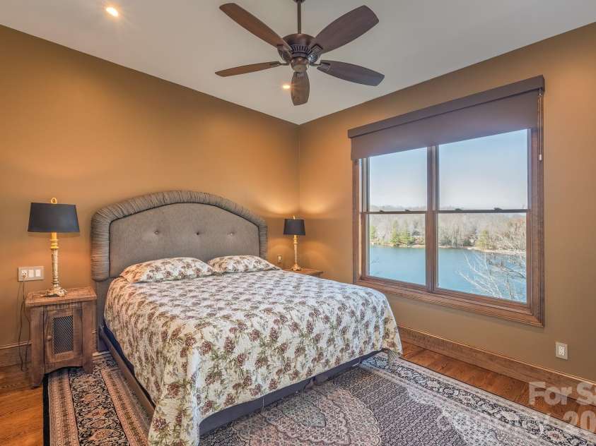 333 Kanasdatsi Drive, Brevard, NC 28712.  MLS# CAR4330137, YatesRealty ID 16902. Lakeview Guest Bedroom – Comfortable and well-appointed bedroom featuring a ceiling fan, warm finishes, and beautiful year-round lake views, creating a peaceful retreat for guests or family.