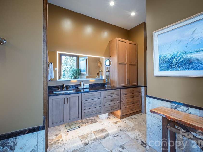 333 Kanasdatsi Drive, Brevard, NC 28712.  MLS# CAR4330137, YatesRealty ID 16902. Primary Bathroom – Elegant tile work and modern fixtures, custom built cabinets, and under cabinet lighting, heated floors with walk in closets nearby