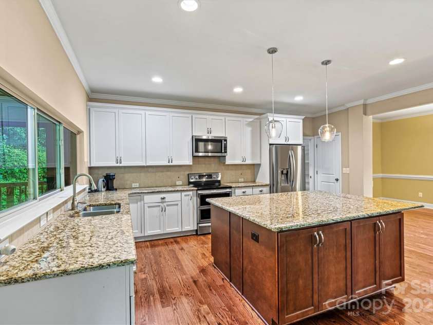 7020 Cedar Ridge Court, Mount Holly, NC 28120.  MLS# CAR4256213, YatesRealty ID 16957. Granite countertops, pendant lighting over island, recessed lighting throughout Kitchen.  Kitchen sink overlooks Sunroom.
