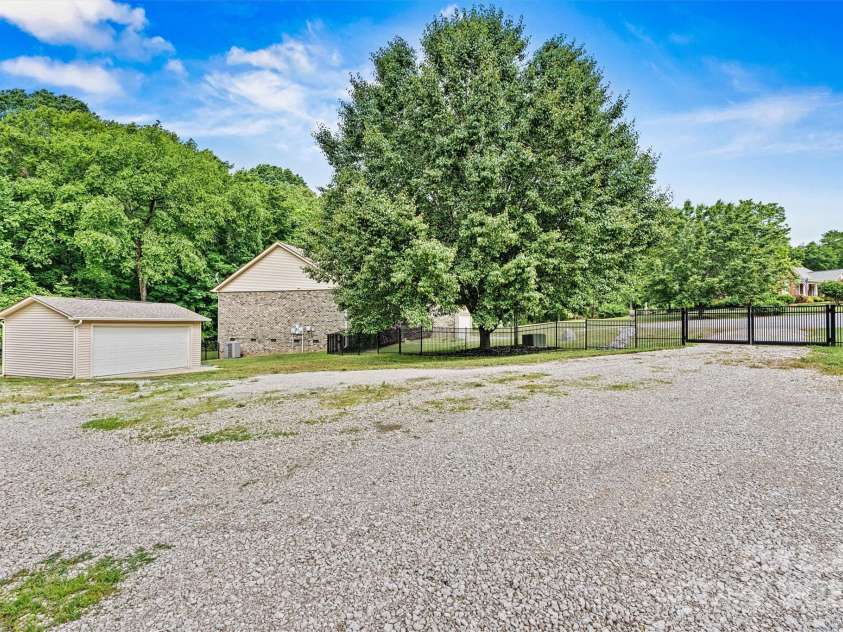 7020 Cedar Ridge Court, Mount Holly, NC 28120.  MLS# CAR4256213, YatesRealty ID 16957. Lot adjacent to home is partially fenced and includes a 50amp RV hookup, plus a 15'x'20' heated and cooled building.  Can be used as an additional garage, as a workshop, etc.  Building has a concrete floor and is 